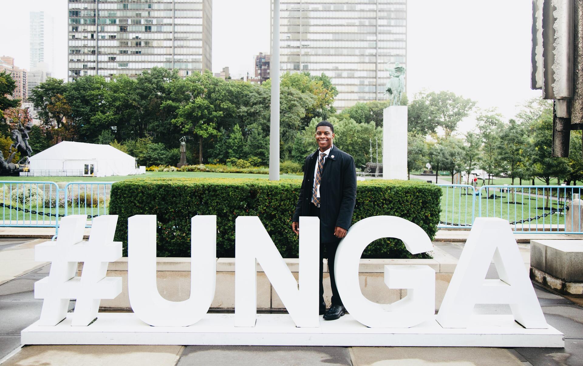 Kevin Dale, Founder and President of World Haus Media Group, standing behind a large #UNGA sign